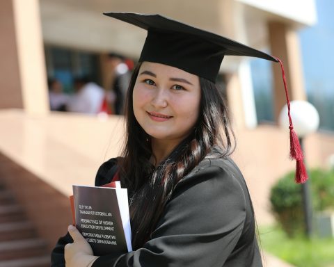 a woman in a graduation gown holding a book