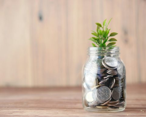 a glass jar filled with coins and a plant