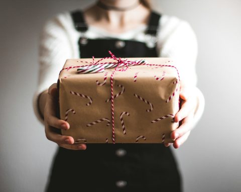 person showing brown gift box