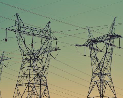 black transmission towers under green sky