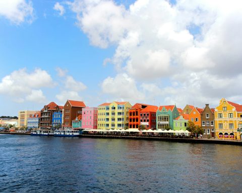 a row of colorful buildings on the side of a body of water