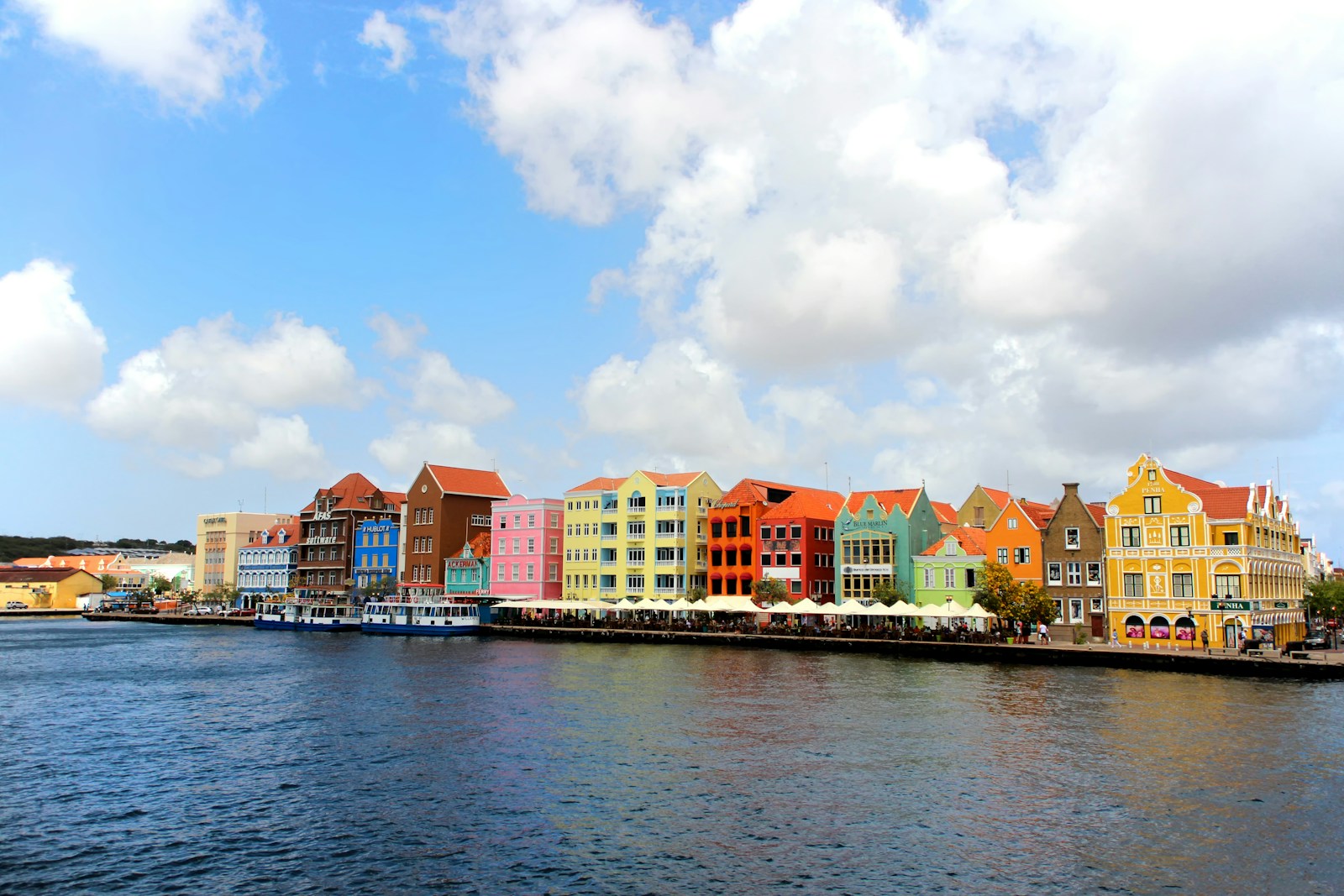 a row of colorful buildings on the side of a body of water