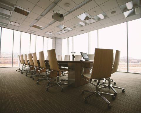 oval brown wooden conference table and chairs inside conference room