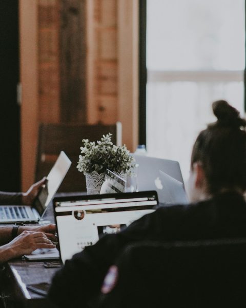 selective focus photography of people sits in front of table inside room