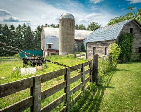 an old farm with a barn and a silo