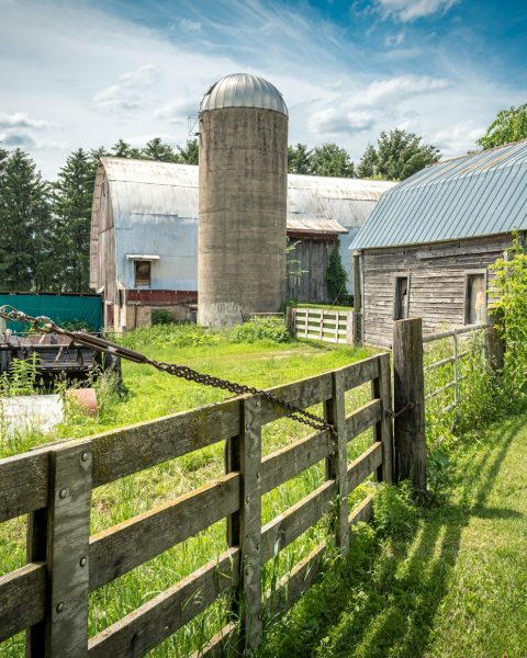 an old farm with a barn and a silo