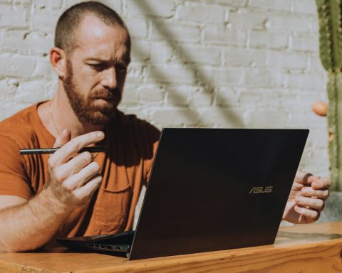a man sitting at a table using a laptop computer