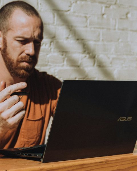 a man sitting at a table using a laptop computer