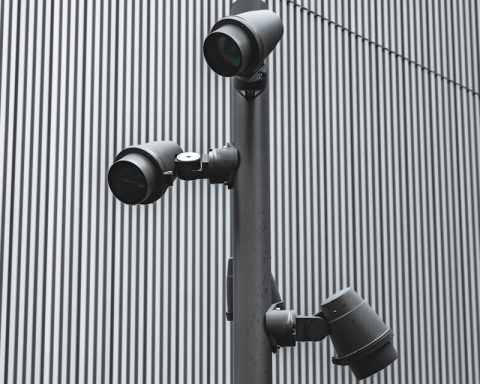 three cameras on a pole in front of a building