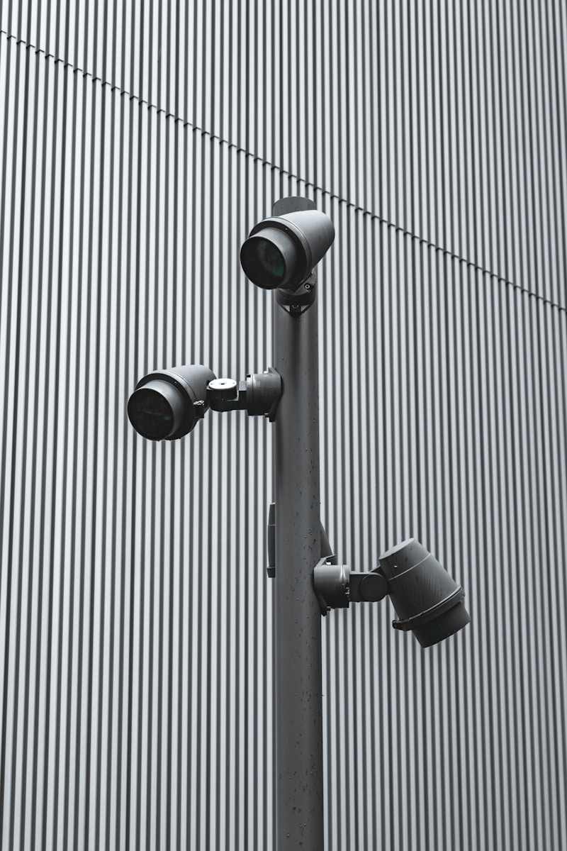 three cameras on a pole in front of a building