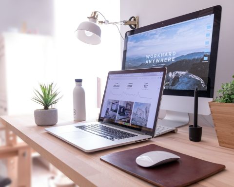 MacBook Pro on table beside white iMac and Magic Mouse