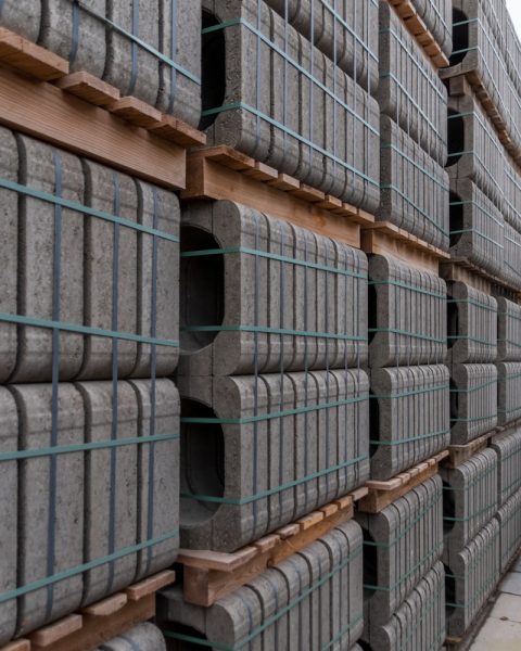 Stacks of gray concrete curbs on wooden pallets