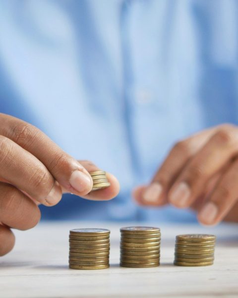 a person stacking coins on top of a table