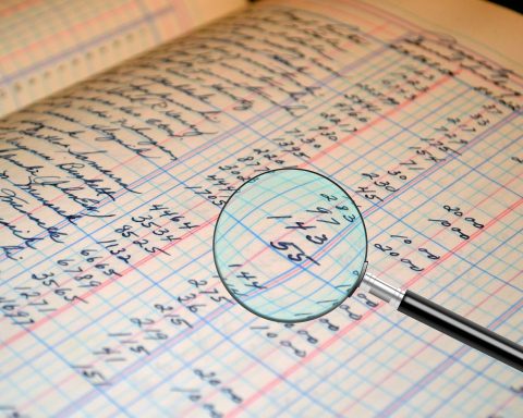 Vrouwelijke ondernemer die financiële documenten doorneemt aan haar bureau