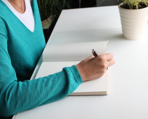 Vrouwelijke ondernemer aan bureau met papieren en laptop voor een financieringsaanvraag