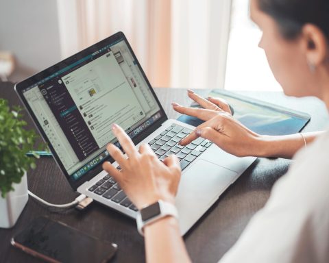 Vrouw die zelfstandig werkt op haar laptop aan een bureautafel thuis