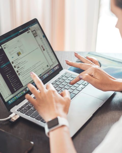 Vrouw die zelfstandig werkt op haar laptop aan een bureautafel thuis
