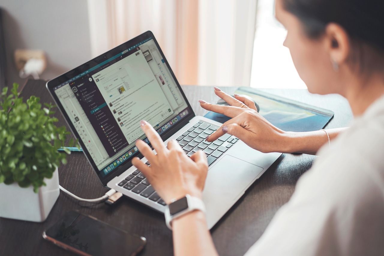 Vrouw die zelfstandig werkt op haar laptop aan een bureautafel thuis