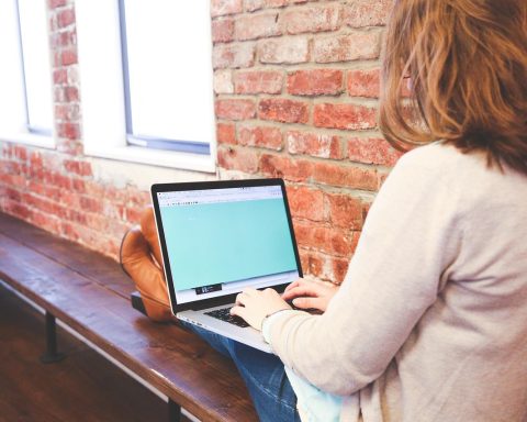 Vrouwelijke ondernemer bekijkt webshop financiën op laptop