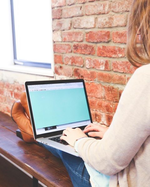 Vrouwelijke ondernemer bekijkt webshop financiën op laptop