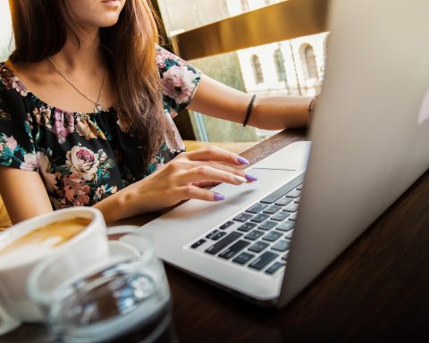 Vrouwelijke ondernemer werkt zomers aan haar laptop op een zonnige werkplek