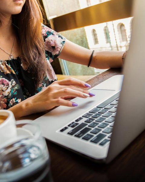 Vrouwelijke ondernemer werkt zomers aan haar laptop op een zonnige werkplek