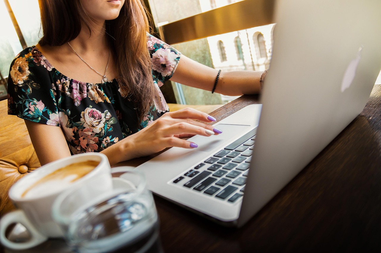 Vrouwelijke ondernemer werkt zomers aan haar laptop op een zonnige werkplek