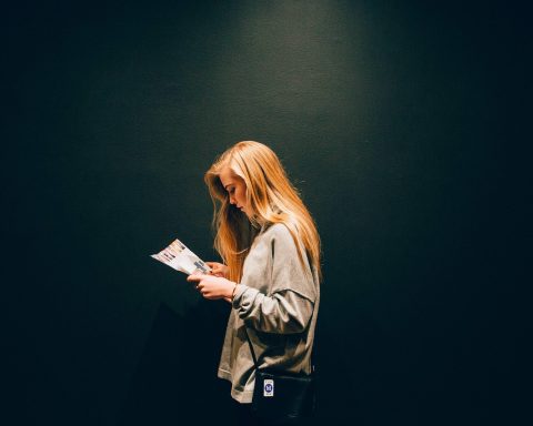 Vrouwelijke ondernemer leest een financieel tijdschrift aan haar bureau