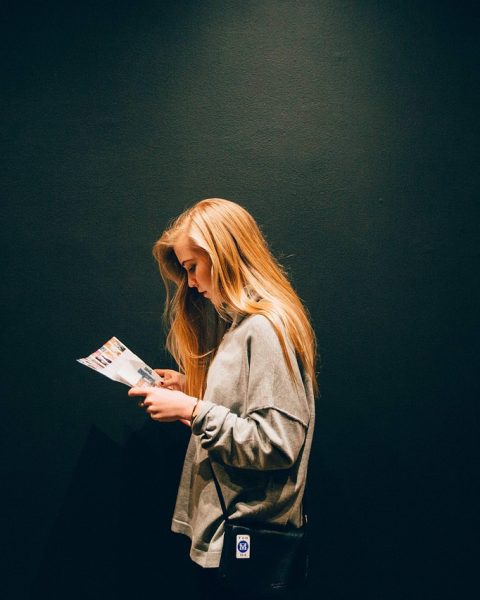 Vrouwelijke ondernemer leest een financieel tijdschrift aan haar bureau