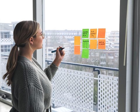 Vrouwelijke ondernemer aan haar bureau bezig met het uitwerken van haar merkstrategie