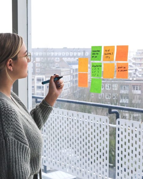 Vrouwelijke ondernemer aan haar bureau bezig met het uitwerken van haar merkstrategie