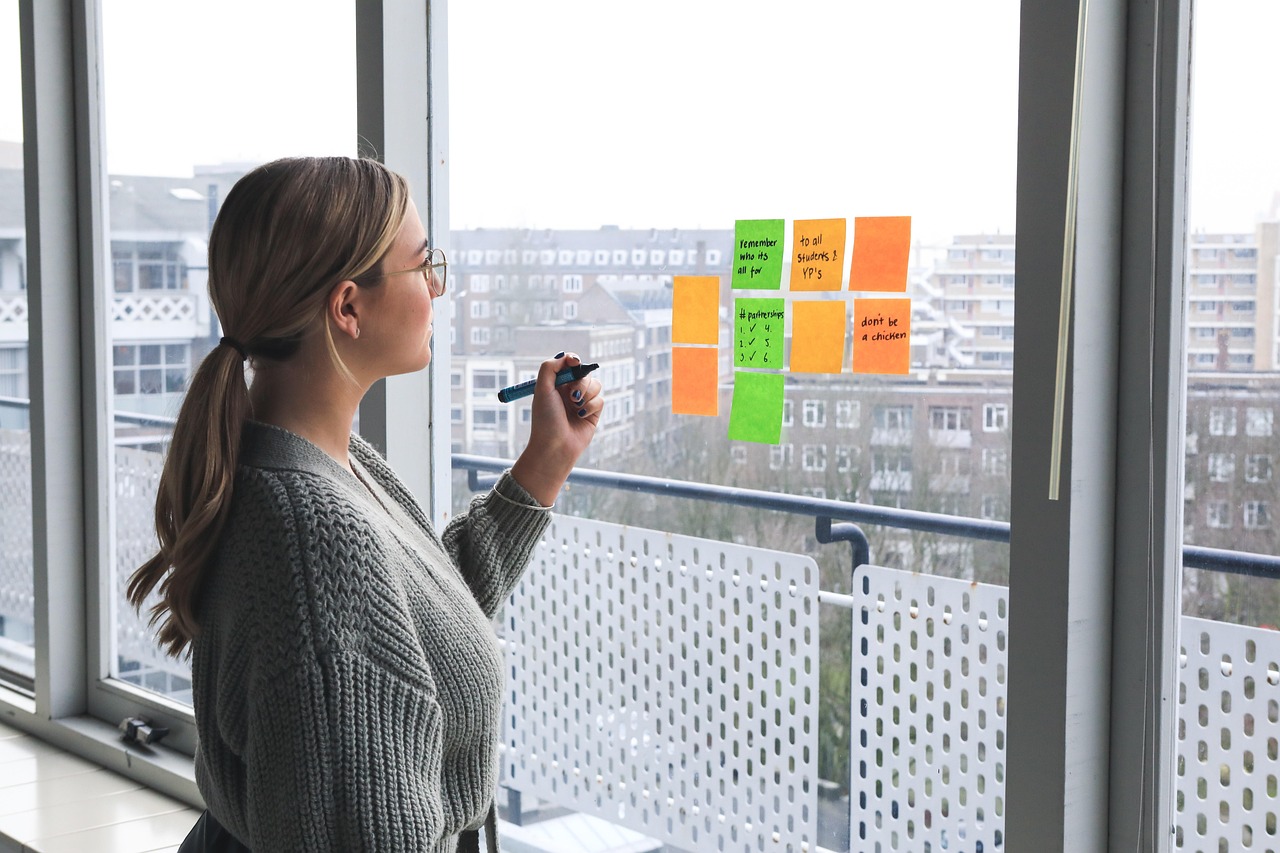 Vrouwelijke ondernemer aan haar bureau bezig met het uitwerken van haar merkstrategie