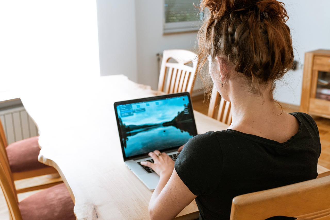 Vrouwelijke ondernemer werkt aan laptop thuis aan haar digitale producten en administratie