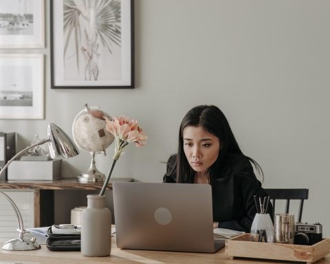 Vrouwelijke ondernemer werkt geconcentreerd op haar laptop in een thuiskantoor