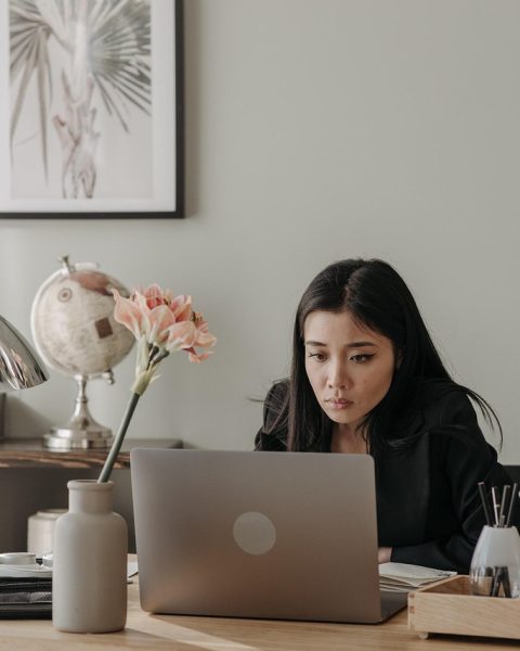 Vrouwelijke ondernemer werkt geconcentreerd op haar laptop in een thuiskantoor