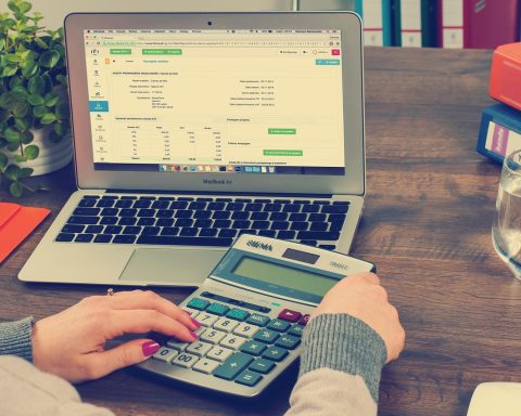 Vrouwelijke ondernemer die financiële documenten doorneemt aan een bureau