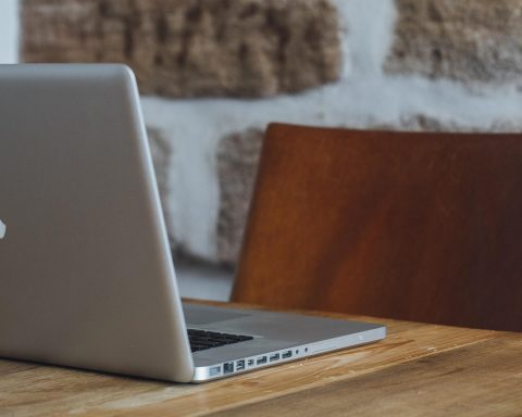 Freelance designer die achter een laptop werkt aan een ontwerpproject