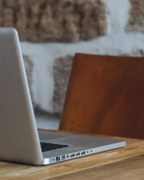 Freelance designer die achter een laptop werkt aan een ontwerpproject
