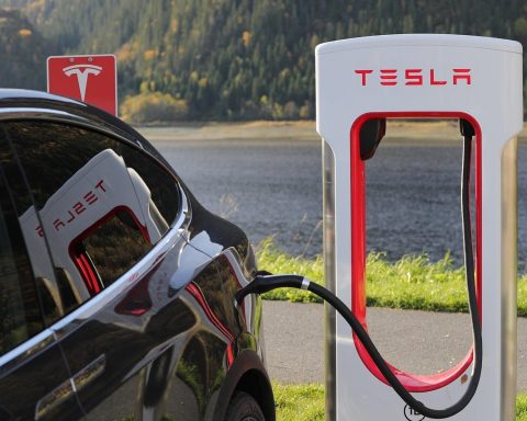 Vrouwelijke ondernemer die haar elektrische auto oplaadt