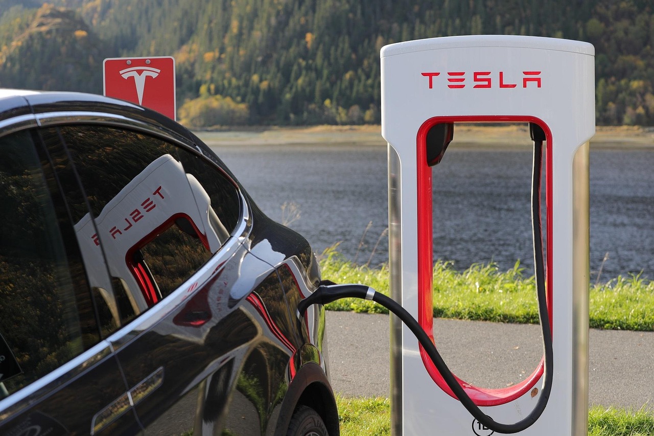 Vrouwelijke ondernemer die haar elektrische auto oplaadt