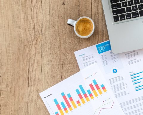 Vrouwelijke ondernemer bekijkt financiële documenten aan bureau