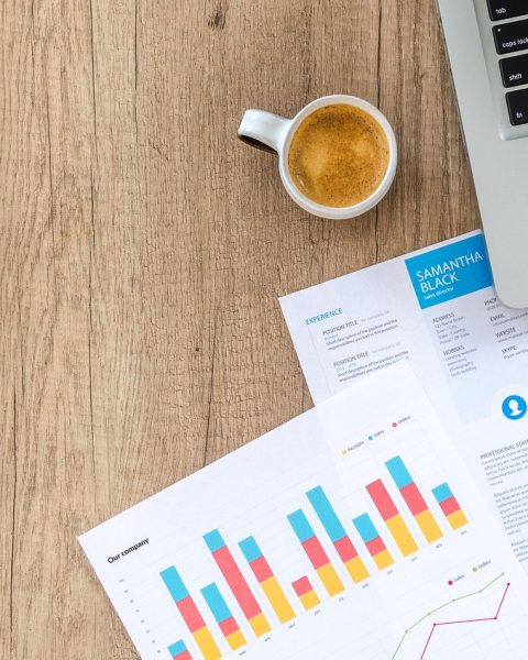 Vrouwelijke ondernemer bekijkt financiële documenten aan bureau