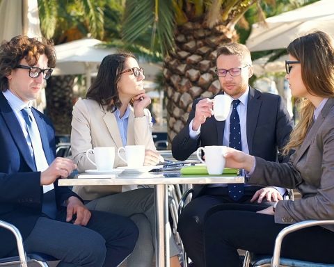 Twee vrouwen voeren een zakelijk gesprek aan een tafel met koffie