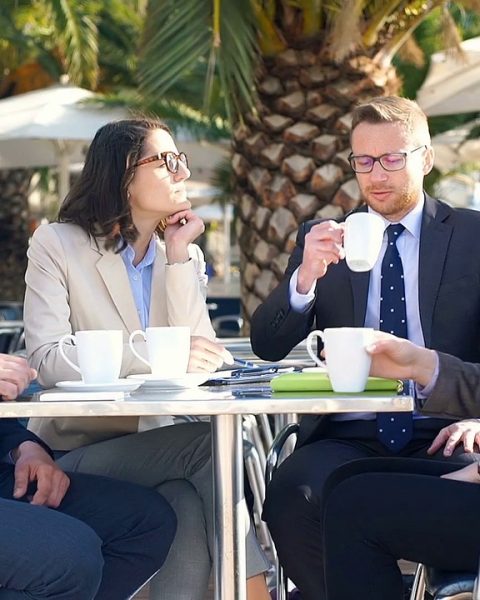 Twee vrouwen voeren een zakelijk gesprek aan een tafel met koffie